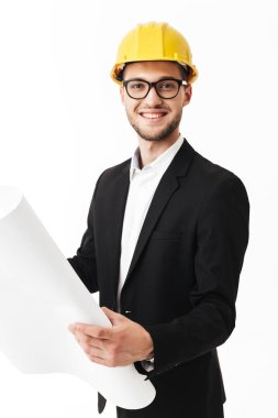 Bussinesman gözlük ve sevinçle kamera tutarak kroki elinde beyaz arka plan üzerinde sarı Emanet kask gülümseyen genç