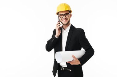 Bussinesman gözlük ve neşe içinde fotoğraf makinesi cellphone planı el ile beyaz arka plan üzerinde konuşurken sarı Emanet kask gülümseyen genç