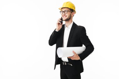 Bussinesman gözlük ve mutlu bir şekilde kenara beyaz arka plan üzerinde cep telefonu planı el ile konuşurken sarı Emanet kask gülümseyen genç