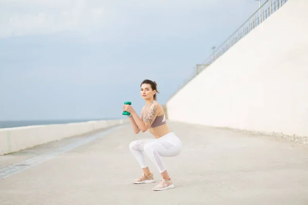 Jovem Mulher Bonita Topo Desportivo Leggings Brancos Fazendo Agachamentos Com — Fotografia de Stock