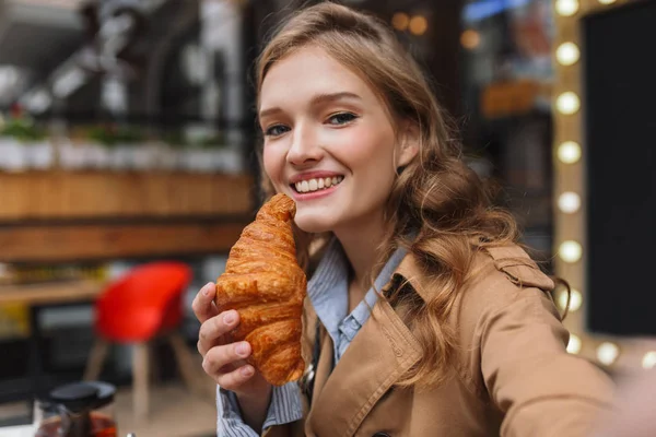 Giovane Donna Allegra Trench Felicemente Scattare Foto Con Croissant Mano — Foto Stock
