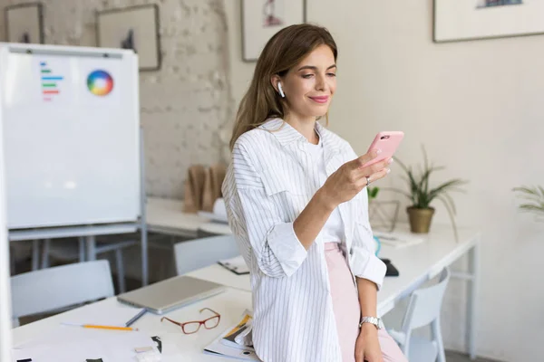 Mooie Lachende Vrouw Wit Shirt Draadloze Oortelefoons Van Leunend Tabel — Stockfoto