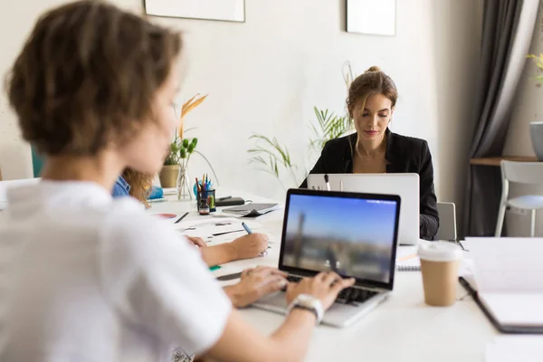 Mulher Pensativa Jovem Que Trabalha Computador Portátil Com Colegas Trabalho — Fotografia de Stock