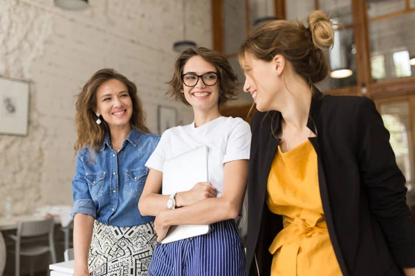 Três Jovens Mulheres Alegres Apoiando Mesa Alegremente Conversando Juntos Passar — Fotografia de Stock
