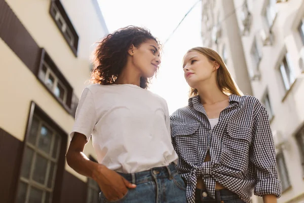 うっとりと見て時間を一緒に過ごして お互いのシャツでブロンドの髪と シャツときれいな女性で暗い巻き毛を持つ若いアフリカ系アメリカ人女性屋外 — ストック写真