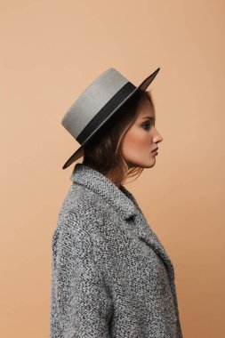 Gri ve bej renkli arka plan üzerinde kat dalgalı saçlı Genç güzel yarım yüz kadın portresi