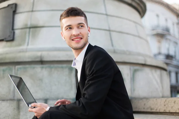 Junger Lächelnder Mann Klassischen Schwarzen Anzug Mit Drahtlosen Kopfhörern Der — Stockfoto