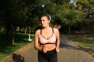 Artı boyutu kadın sportif üst ve ne yazık ki bir kenara çalışan arıyorsunuz şehir parkında tozluk genç yorgun 