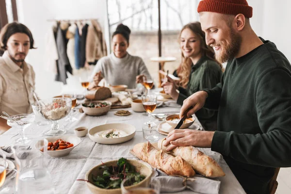 Guapo Hombre Sonriente Con Sombrero Barba Sentado Mesa Cortando Baguettes — Foto de Stock