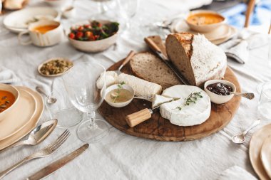 Taze ekmek kadar kapatın ve soslar ahşap tahta üzerinde peynir. Beyaz masa tam gıda Cafe