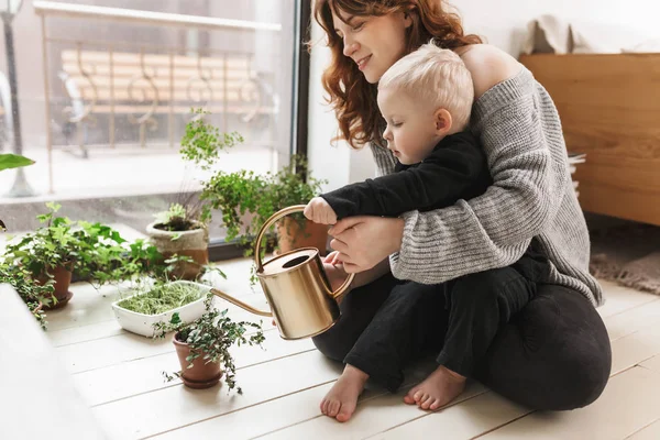 Joven Hermosa Mujer Sonriente Sentada Suelo Con Pequeño Hijo Sosteniendo — Foto de Stock