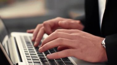 Erkek el laptop klavye üzerinde arka plan caddenin ile yazarak görüntüsünü kapatın. İşadamı metin yazma