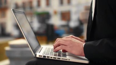 Erkek el laptop klavye üzerinde arka plan caddenin ile yazarak görüntüsünü kapatın. İşyeri dışında yazarak işadamı