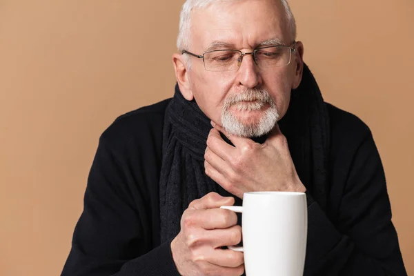 Old sick man with gray hair and beard in eyeglasses and scarf wi