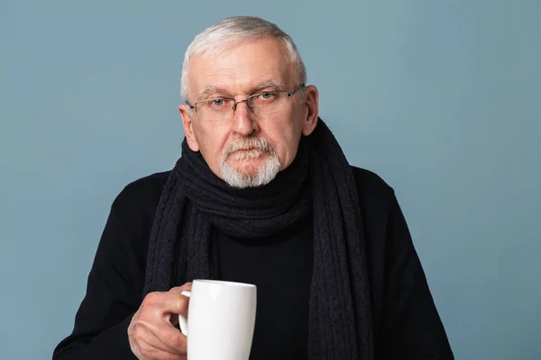 Old sick man with gray hair and beard in eyeglasses and scarf th