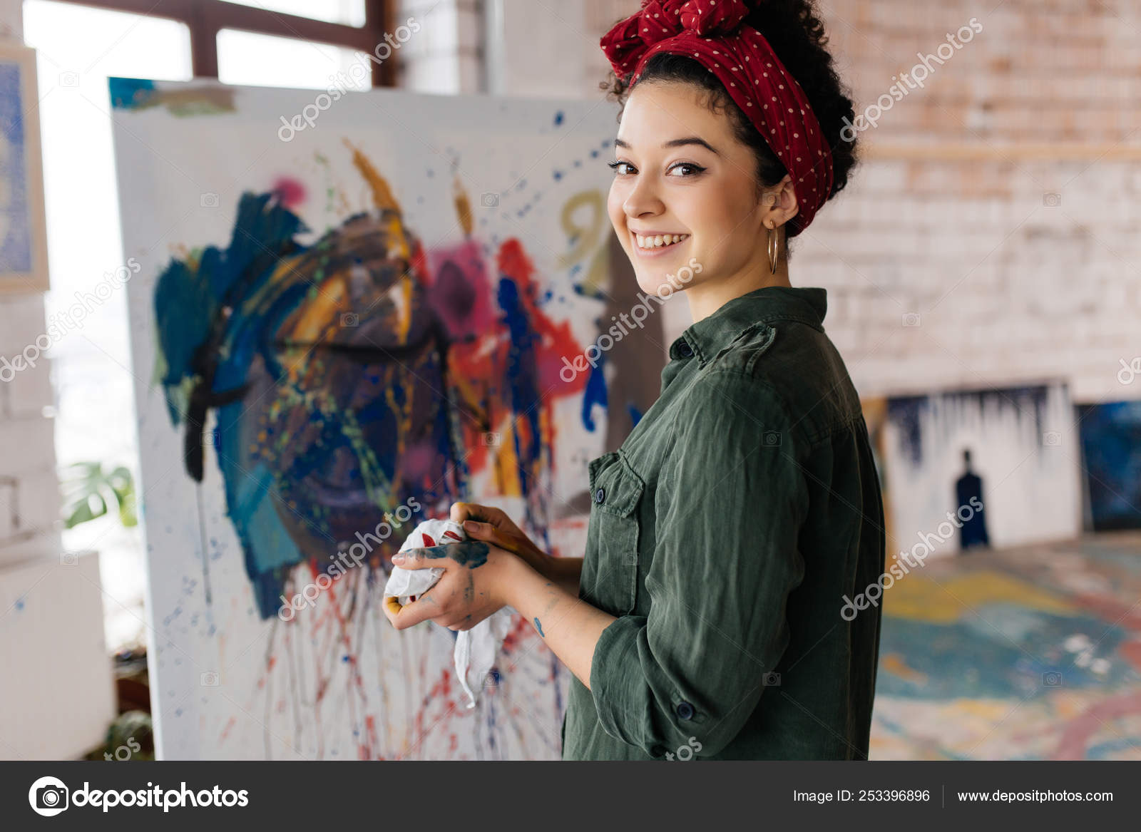 Young pretty smiling woman with dark curly hair drawing picture Stock Photo by ©Garetsworkshop 253396896 Young pretty smiling woman with dark curly hair drawing picture Stock Photo by ©Garetsworkshop 253396896