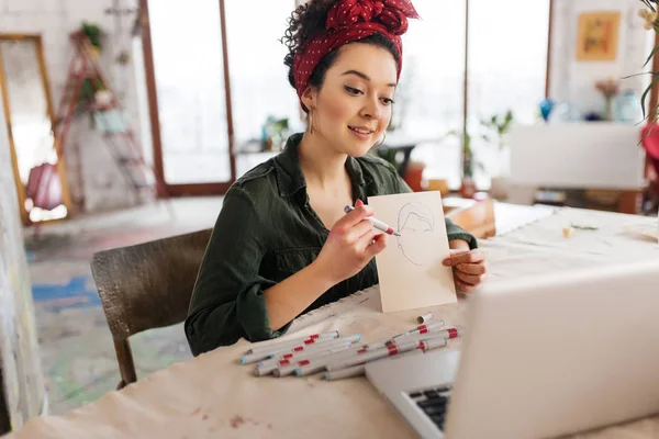 Young attractive woman with dark curly hair sitting at the table — Stock Photo, Image