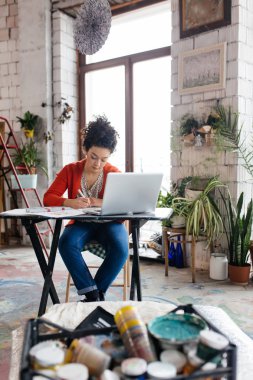 Masada oturan Koyu kıvırcık saçlı Genç güzel kadın 