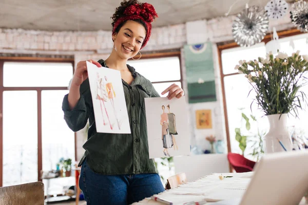 Jonge vrolijke vrouw met donker krullend haar staande in de buurt van tafel happ — Stockfoto