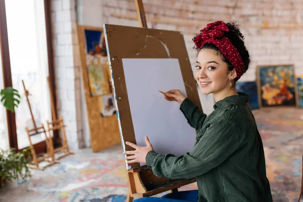 Joven hermosa mujer sonriente con pelo rizado oscuro sentado en ch — Foto de Stock