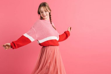 Young pretty smiling girl with two braids in sweater and long sk