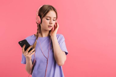 Young attractive girl with two braids in lilac t shirt listening