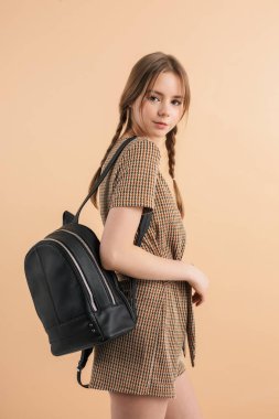 Yünlü tulum giymiş iki örgülü güzel, gülümseyen kız.