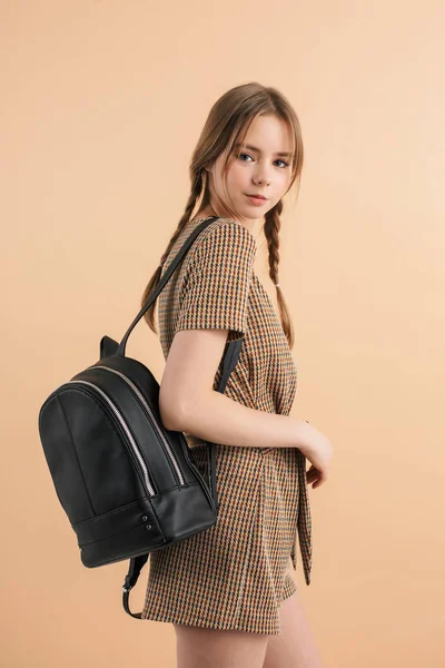 Yünlü tulum giymiş iki örgülü güzel, gülümseyen kız.