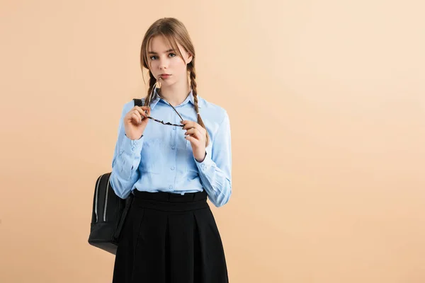 Jong aantrekkelijk meisje met twee vlechten in blauw shirt en rok wi — Stockfoto