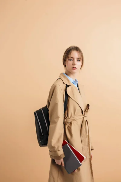 Young beautiful lady in trench coat with backpack on shoulder ho — Stock Photo, Image