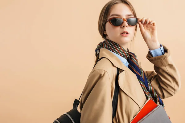 Jovem senhora atraente em casaco de trincheira e óculos de sol com backpac — Fotografia de Stock