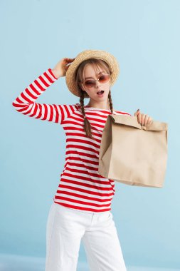 Hasır şapkalı ve kırmızı güneşli genç ve çekici bir kız.