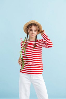 Hasır şapkalı, kırmızı çizgili yeleği olan genç ve güzel bir kız. 