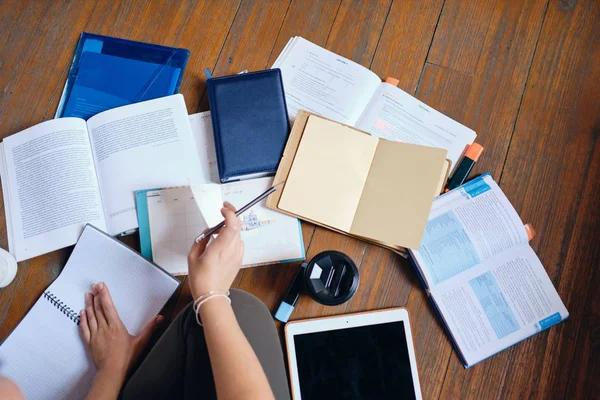 Foto ravvicinata della ragazza che tiene in mano la matita studiando con tablet, libri e tazza di caffè per andare a casa — Foto Stock