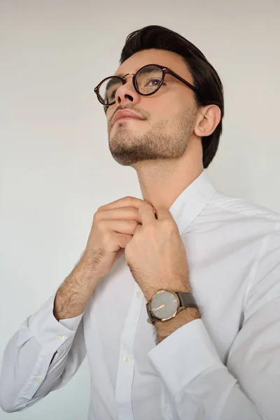 Fiatal csinos barna férfi, fehér inget és szemüvegek nézni meggondolóan nézett félre, fehér háttér előtt — Stock Fotó