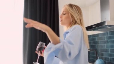 Orta erkek gömlek çekici sarışın kadın çekim dışarı izleme rüya gibi modern evde mutfakta şarap kadehi ile dans