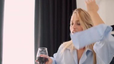 Erkek gömlek güzel sarışın kadın çekim izleme hayalrüya gibi dans ve modern mutfakta şarap kadehi ile şarkı