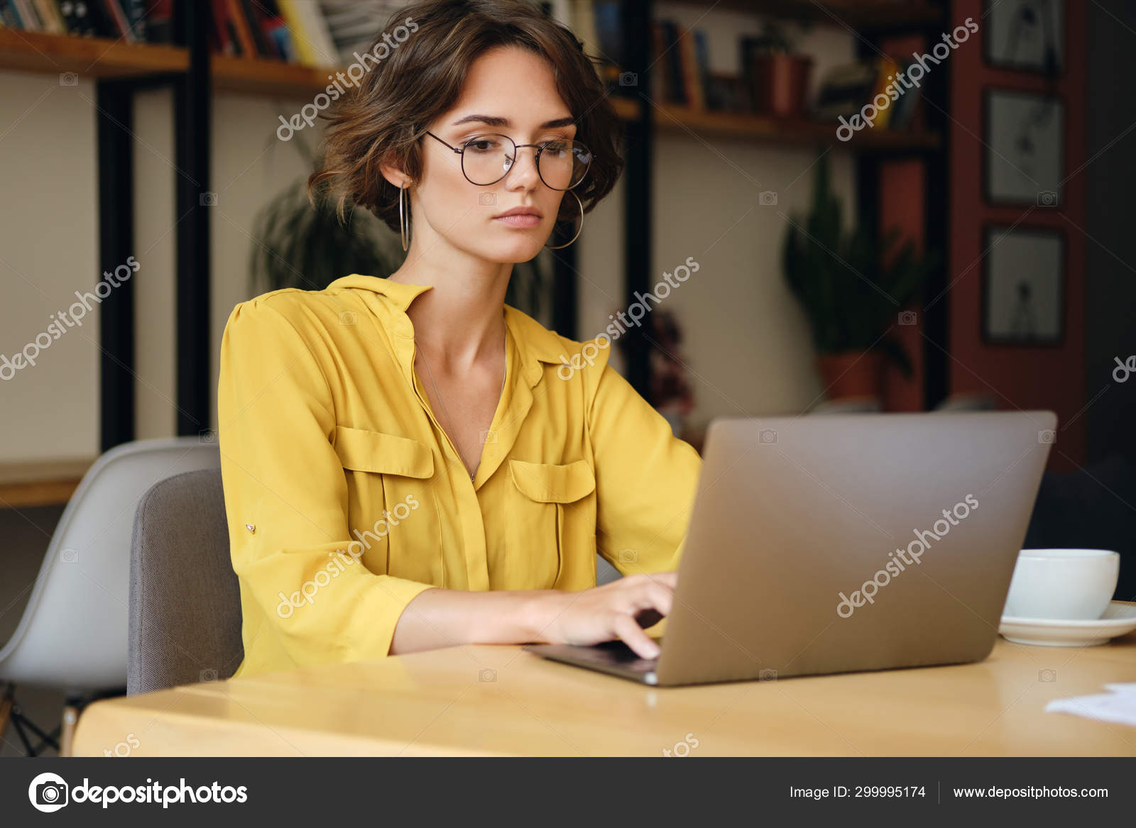 Mujer con gafas usando laptop. Empresaria encantadora en anteojos y ropa  casual que trabaja con la pantalla de observación del ordenador portátil.  Elegante mujer de negocios de longitud completa tiro vertical Fotografía