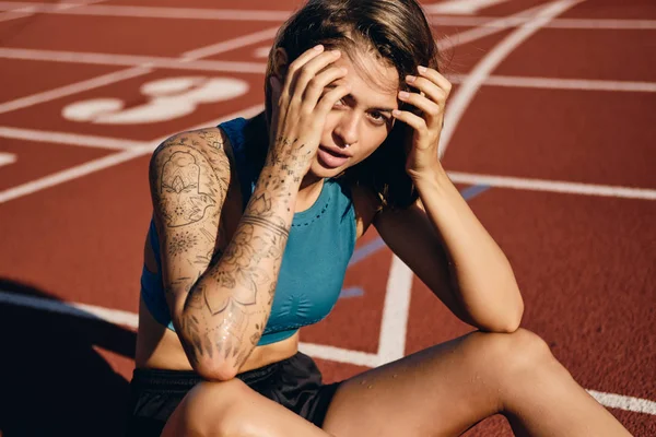 Όμορφη υγρή αθλήτρια κορίτσι σε αθλητικά είδη αισθησιακά αναζητούν στην κάμερα αναπαύσεως μετά από τρέξιμο στο στάδιο της πόλης — Φωτογραφία Αρχείου