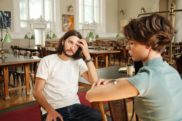 年轻的休闲男学生在大学教室里为老师进行口头考试 — 图库照片