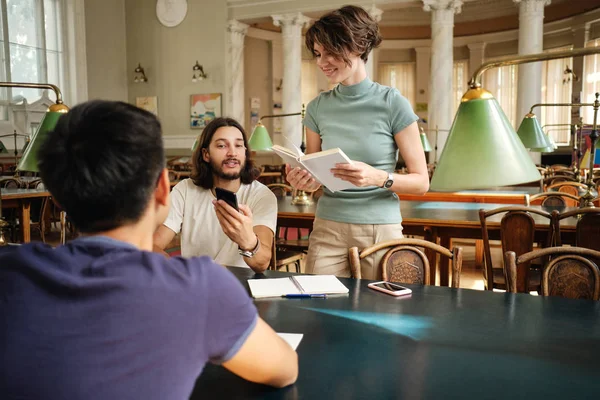 Gruppo di giovani studenti casuali felicemente studiare insieme in biblioteca di università — Foto Stock