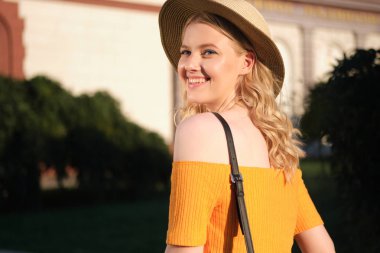 Güzel romantik sarışın kız portresi şapka sevinçle şehir caddesinde uzağa bakarak