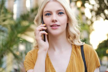 Güzel sarışın kız portresi düşünceli kamera cep telefonu açık konuşma bakıyor