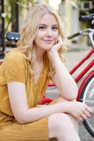 Портрет красивой романтической блондинки в платье мечтательно смотрящей в камеру на городской улице — стоковое фото