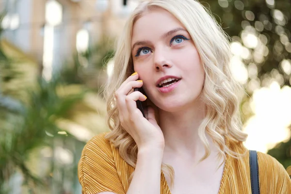 Portrait d'une jolie fille blonde coûteuse parlant avec réflexion sur le téléphone portable en plein air — Photo
