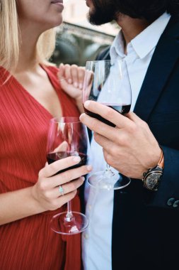 Restoran açık nişan kutlayan kırmızı şarap bardakları ile şehvetli çift kapatın