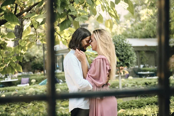 Junges schönes lächelndes Paar umarmt sich glücklich bei romantischem Date im Freien — Stockfoto