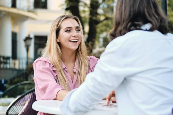 Junge, gut gelaunte Frau im Kleid schaut Freund bei romantischem Date im Café glücklich an — Stockfoto