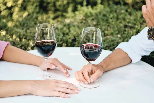 Pareja cercana con copas de vino tinto en una cita romántica en el restaurante al aire libre — Foto de Stock