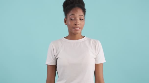 Zamyšlená Africká Americká Dívka Provinile Dívá Kamery Nad Modrým Pozadím — Stock video